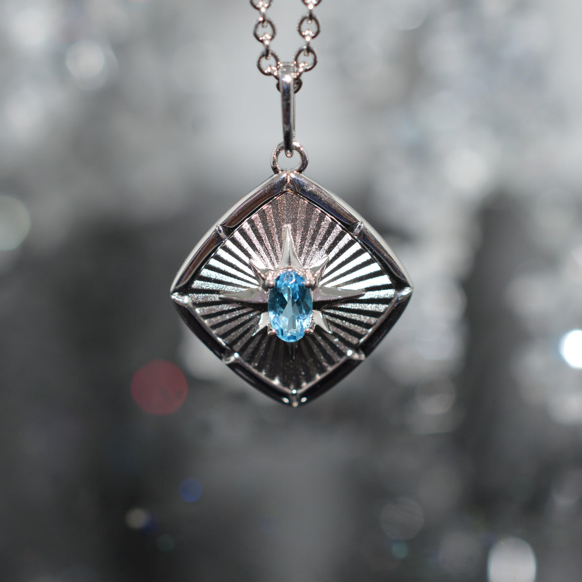 Sterling Silver Chain With Square Sunburst Pendant Set With Oval Blue Topaz