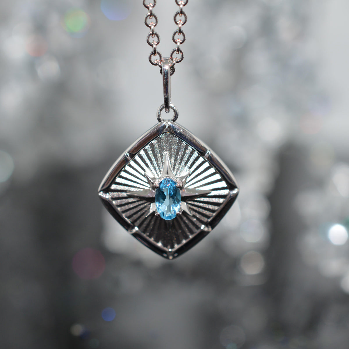 Sterling Silver Chain With Square Sunburst Pendant Set With Oval Blue Topaz