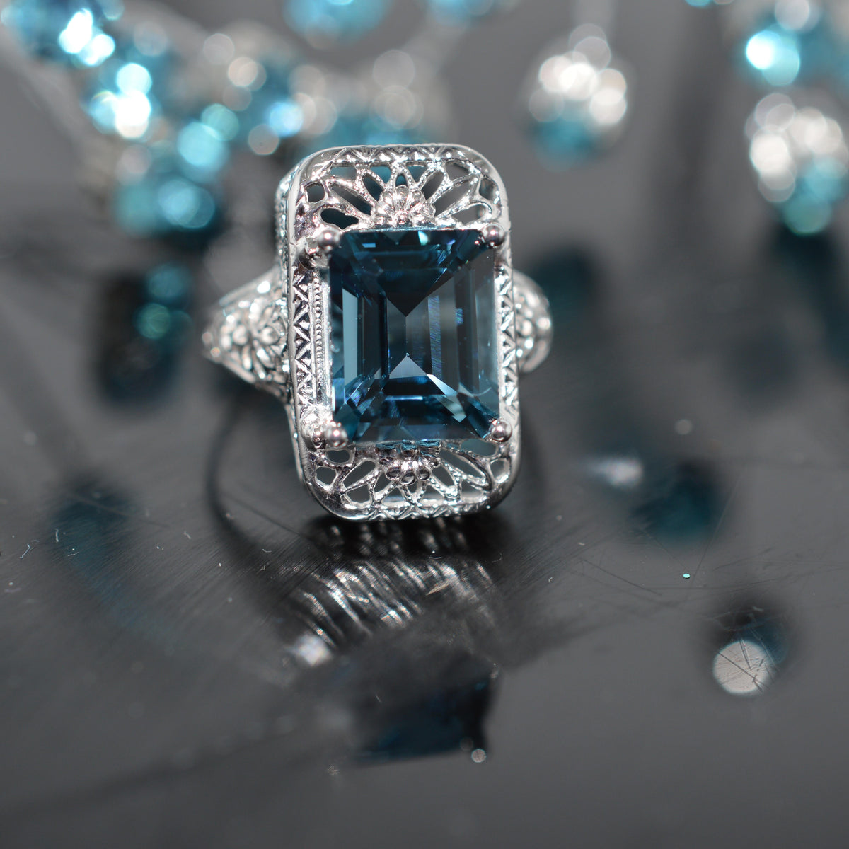 14K White Gold Filigree Ring With An Emerald Cut Blue Topaz