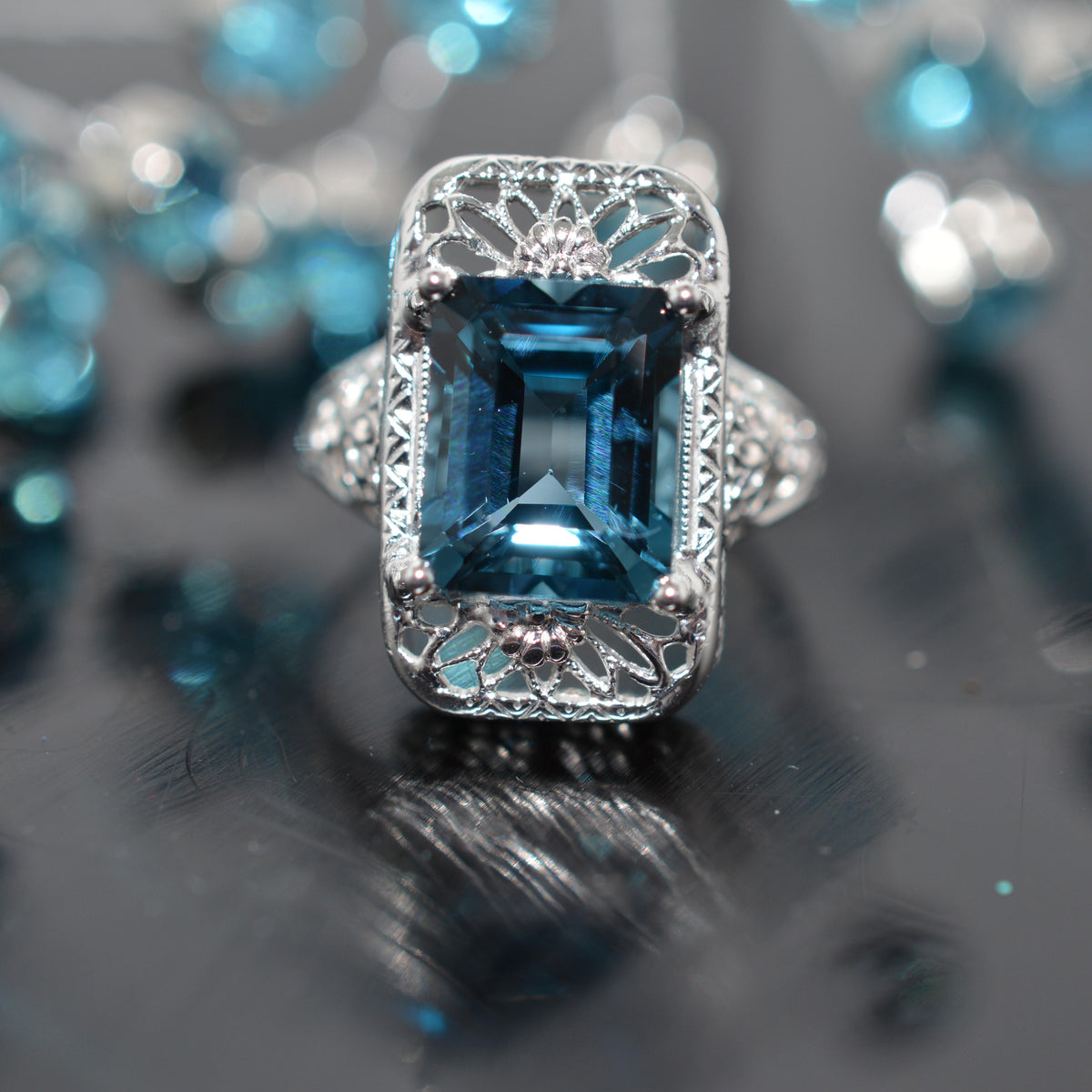 14K White Gold Filigree Ring With An Emerald Cut Blue Topaz